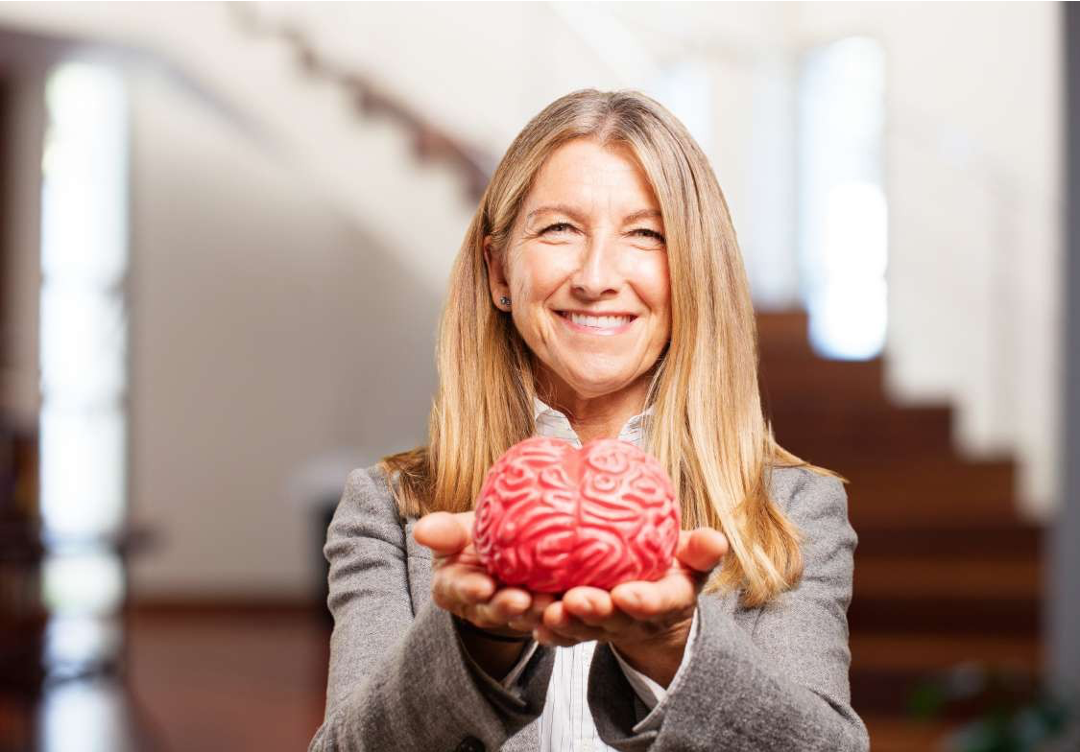 Žena s dlouhými vlasy drží v rukách plastový model mozku