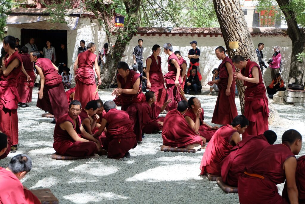 Mniši v Tibetu v červených hábitech meditují