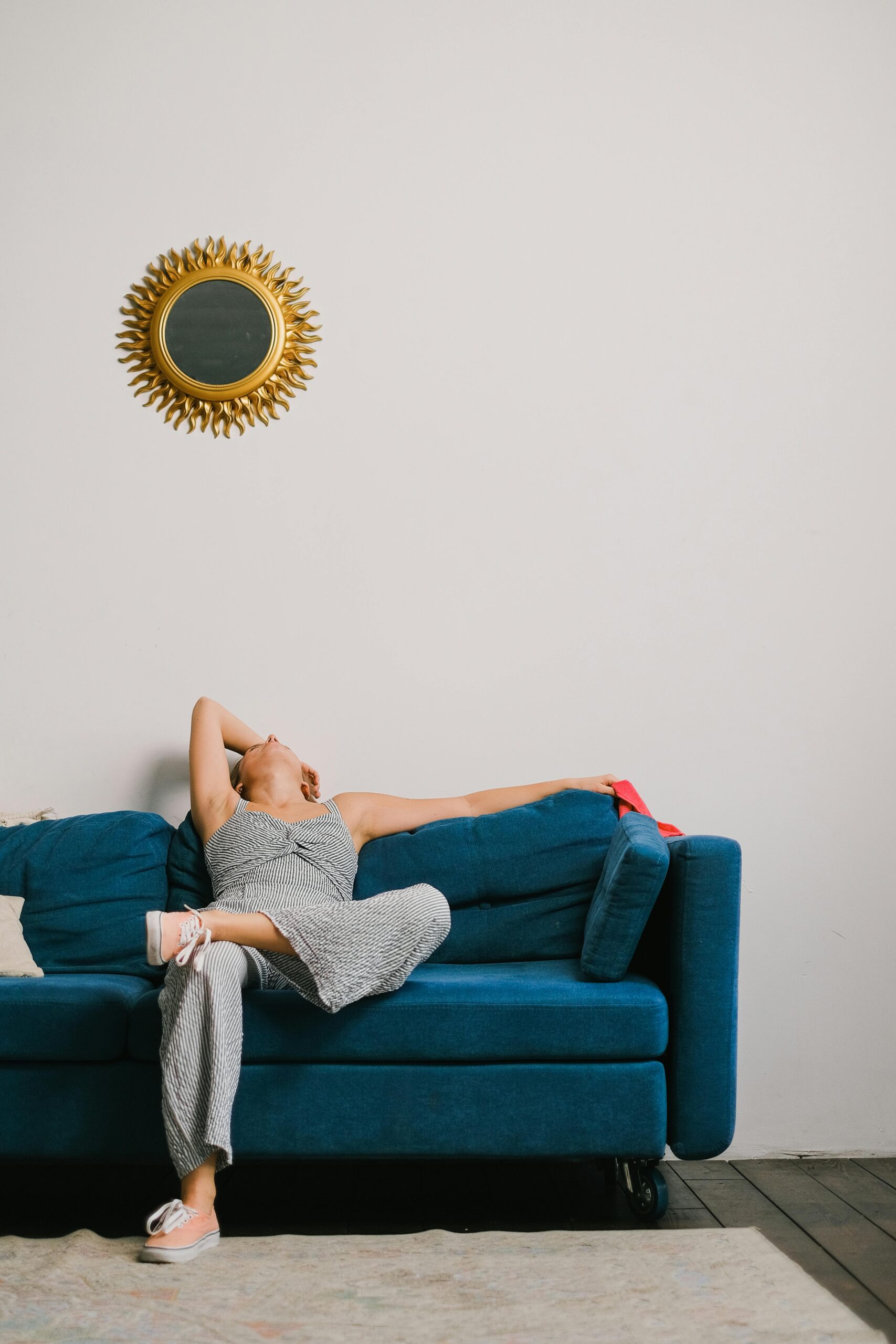 unavená žena sedí na modrém sofa