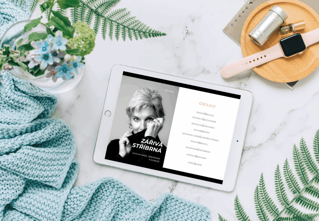 tablet ležící na stole, na kterém je otevřena první stránka e-knihy a její obsah